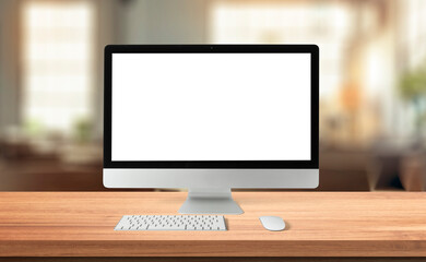 Computer desktop with blank screen on wood table in blurry background with house or office modern ,nature orange bokeh and sunlight in morning.