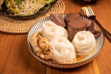 Rice noodles or Kkanomjeen namya krati in fish curry sauce with blood tofu and Chicken feet, Rice vermicelli with minced fishes and coconut milk in red curry.