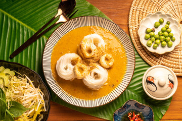 Rice noodles or Kkanomjeen namya krati in fish curry sauce with vegetables, Rice vermicelli with minced fishes and coconut milk in red curry.
