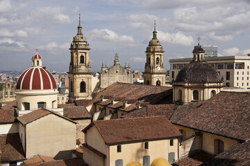 Fototapeta na wymiar Rooftops, domes, and towers of historic buildings in La Candelaria district of Bogota, Colombia, with La Catedral Primada and Capilla Sagrario in foreground