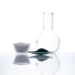 Carbon Charcoal Powder in Chemical Watch Glass place next to Cetyl esters wax in glass container and Flat Bottom Flask. Side View