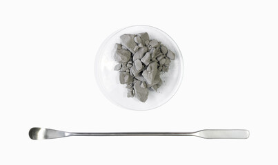 Aluminium powder in Chemical Watch Glass placed next to the stainless spatula. Closeup chemical...