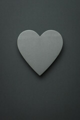 Light gray wooden heart on a black background. Space for text.