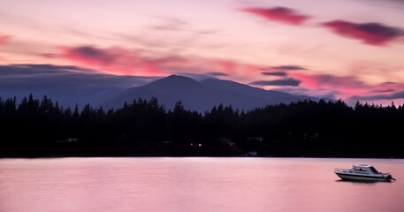 pink sunset and purple mountains with motor boat