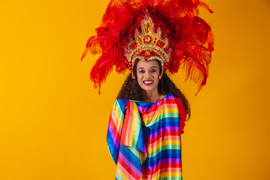 Beautiful afro woman in lgbt flag carnival outfit on yellow background.
