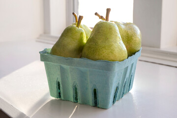 green pears in blue fruit carton
