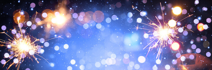 Fototapeta na wymiar Happy New Year background with glowing sparklers.