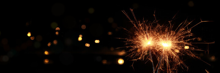 Happy New Year background with glowing sparklers.