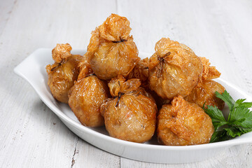 Ekado or ekkado is processed fish or shrimp meat wrapped in dumpling skin and shaped like a bag filling with cheese whose upper part is tied with chives.