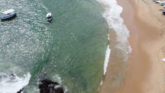 Aerial view of Coastline with Sea waves, rocks and boats revealing City of Salvador of Carnival, state of Bahia Brazil. Tropical Travel Destination Urban environment.