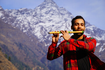 bansuri indian instrument Young boy playing bansuri Indian flute in mountains
