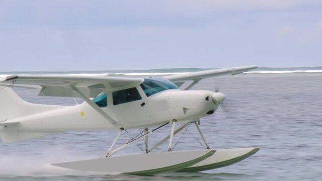 White sea plane landing in a calm lagoon