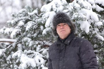 Fototapeta na wymiar A man on a walk in the park in a snowfall