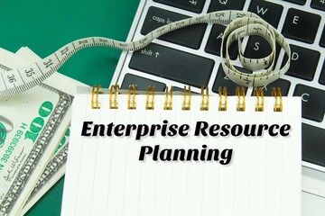 Fototapeta na wymiar laptop keyboards, banknotes and notebooks with the words enterprise resource planning
