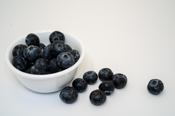 blueberries in a bowl with white smooth background, blank space for writing