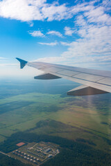Obraz premium View from the airplane window at a beautiful blue sunrise and the airplane wing in clear sky.