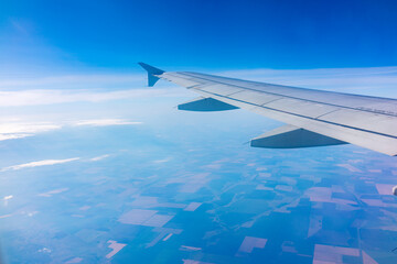 View from the airplane window at a beautiful blue clear sky and the airplane wing