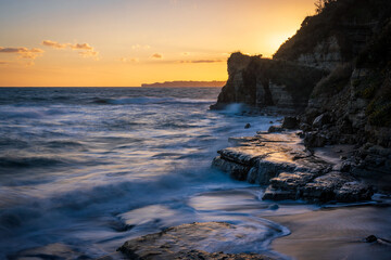 A sunset view from the rugged shore.