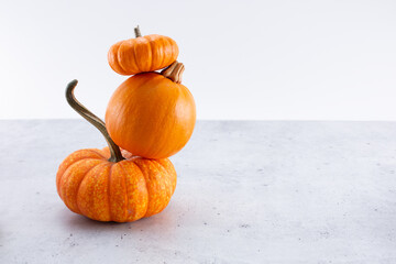 A view of a stack of three small pumpkins, on the left side of the frame.
