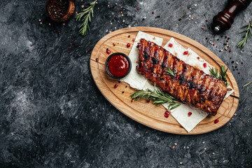 Spicy hot grilled spare ribs BBQ served on wooden cutting board, banner, menu, recipe place for...