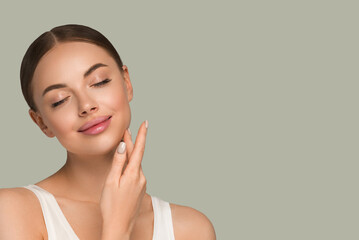 Beauty healthy skin women touching face cosmetic studio portrait. Sportswear color background green