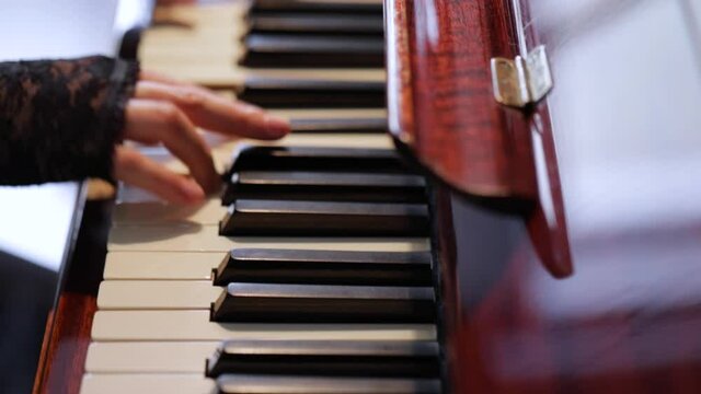 Woman playing on vintage wooden piano