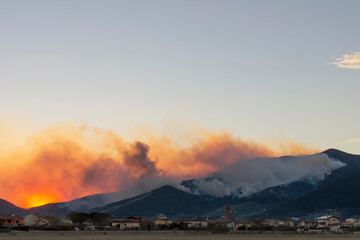 Panoramic view of a vast fire on Monte Pisano near Bientina, Italy, at sunset time