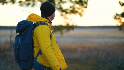 Man backpacker walking on pine forest. Successful man hiker with backpack at sunset time. Travel lifestyle wanderlust concept adventure outdoor vacations wild nature.