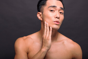 Close up of satisfied confident handsome guy touching with shaved flawless clean soft skin