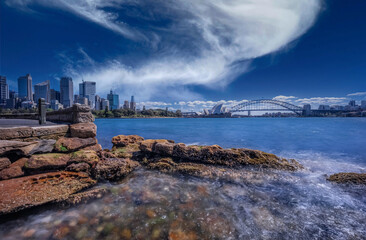 View of Sydney Harbour NSW Australia. Ferry boats partly cloudy colourful skies blue waters