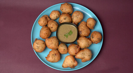 Delicious Indian snacks Punugulu served in a plate with Tomato and green Chutney