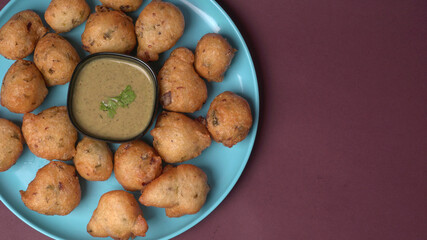 Delicious Indian snacks Punugulu served in a plate with Tomato and green Chutney