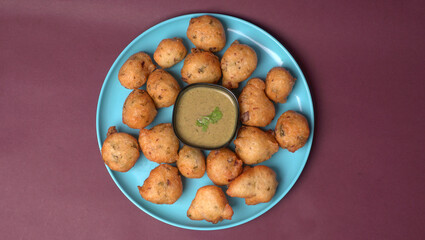 Delicious Indian snacks Punugulu served in a plate with Tomato and green Chutney