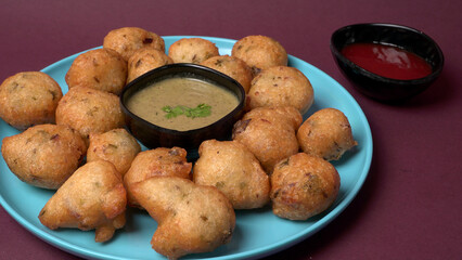 Delicious Indian snacks Punugulu served in a plate with Tomato and green Chutney