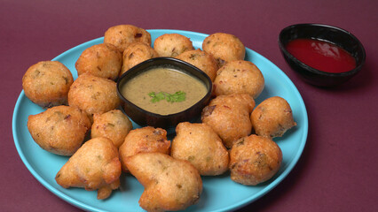 Delicious Indian snacks Punugulu served in a plate with Tomato and green Chutney