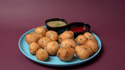 Delicious Indian snacks Punugulu served in a plate with Tomato and green Chutney