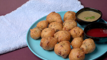 Delicious Indian snacks Punugulu served in a plate with Tomato and green Chutney