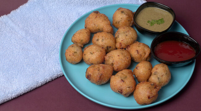 Delicious Indian snacks Punugulu served in a plate with Tomato and green Chutney