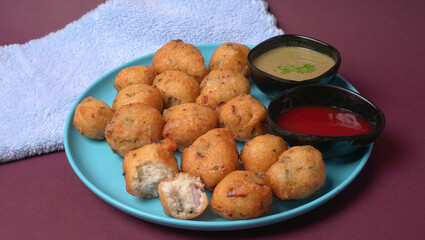 Delicious Indian snacks Punugulu served in a plate with Tomato and green Chutney