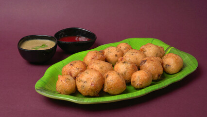 Delicious Indian snacks Punugulu served in a plate with Tomato and green Chutney