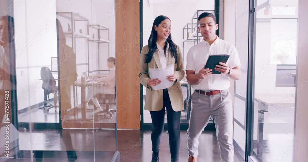 Poster Office workers walking in a busy office discussing. a new idea and strategy. Serious managers in suits consulting during a walk through a modern office. Planning a strategy on a tablet