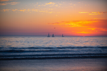 Fototapeta na wymiar Calm sea with sunset sky and sun through the clouds over. Ocean and sky background, seascape.