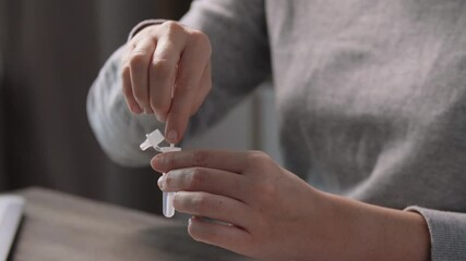 medicine, quarantine and pandemic concept - woman taking sample from her nose with swab and making self testing nasal coronavirus test at home