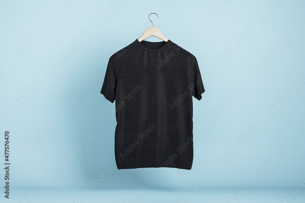 Poster empty black tshirt hanging on blue wall background. product design and presentation concept. mock up