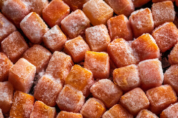 Frozen fresh carrot cube pieces closeup background