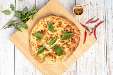 Basil and minced pork green curry pizza on a wood board