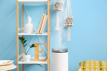 Modern humidifier and book shelf near color wall