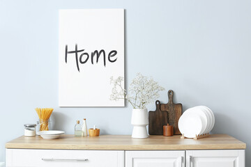 Vase with gypsophila flowers on kitchen counter near light wall