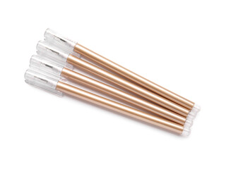 Golden pens on white background