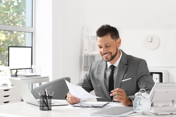 Smiling businessman working at table in office
